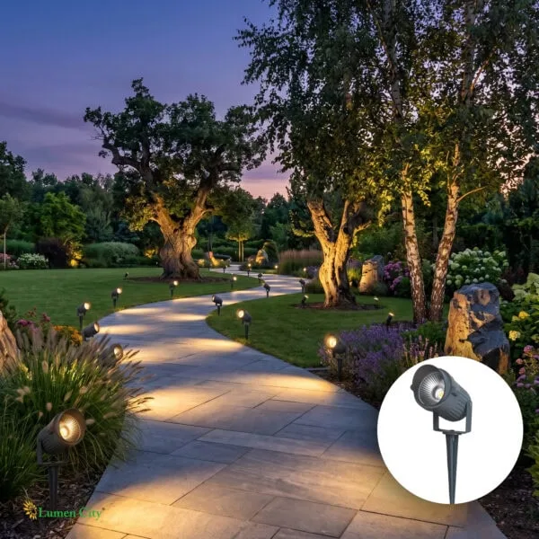 Sunset garden pathway illuminated by landscape lighting, surrounded by lush trees and vibrant flower.
