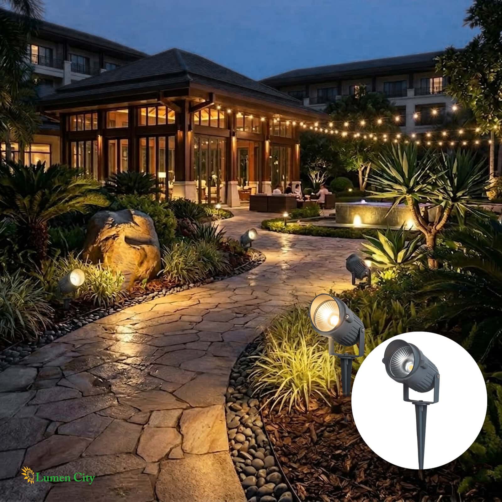 Elegant garden pathway illuminated with outdoor lighting and string lights at night.