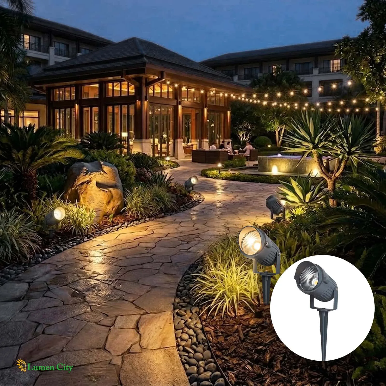 Elegant garden pathway illuminated with outdoor lighting and string lights at night.