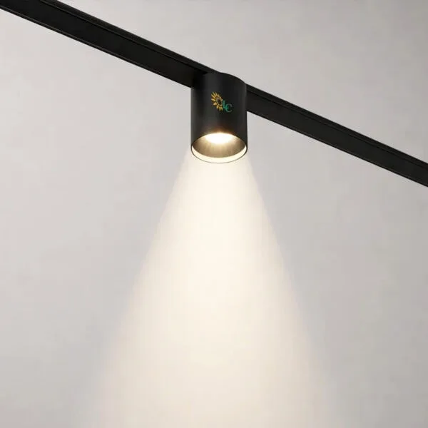 Adjustable black track light illuminating a white wall, modern lighting fixture for stylish interior.